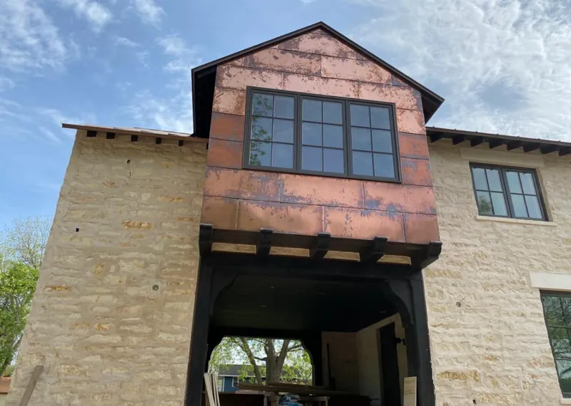 Copper metal panel facade on a stone building for Metal Roof Coating in Indianola